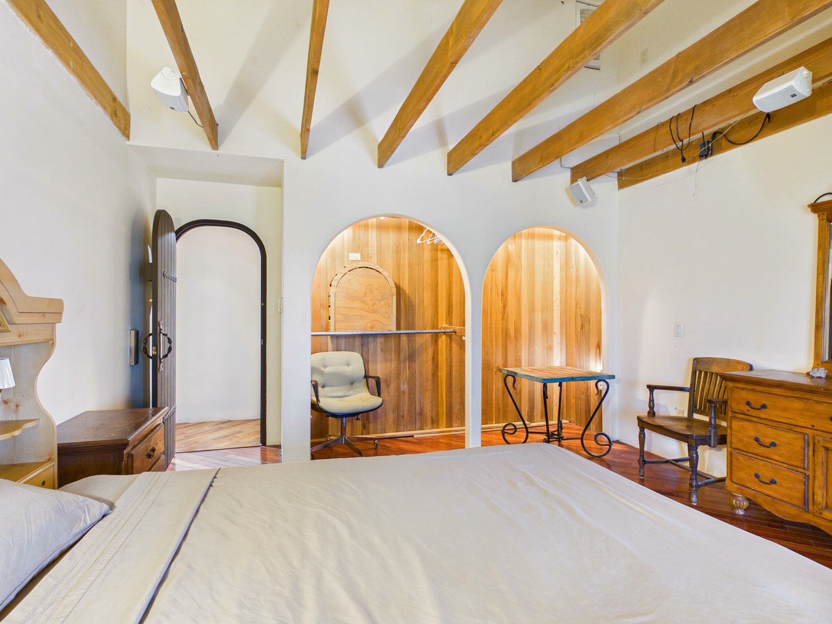 A bedroom beneath beamed ceilings