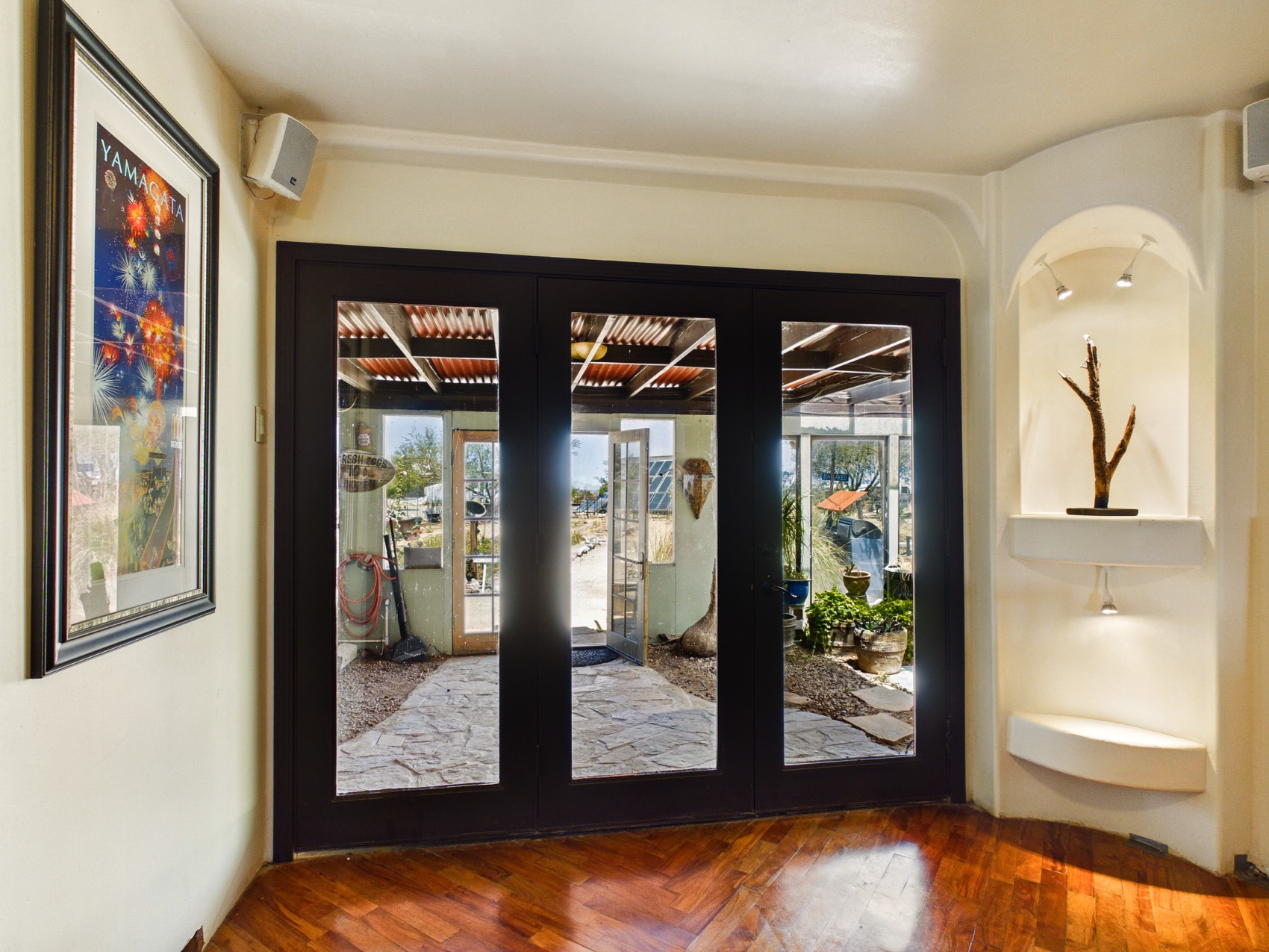 The entry — triple glass doors and a sculpture nicho